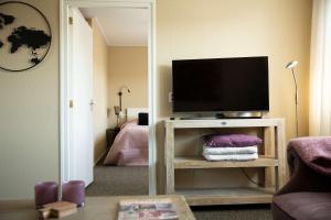 a living room with a flat screen tv on a table at Hello Zeeland - Appartement Weststraat 14 in Domburg