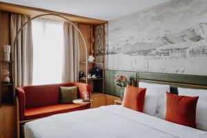 ein Hotelzimmer mit einem Bett und einem Stuhl in der Unterkunft AMERON Luzern Hotel Flora in Luzern