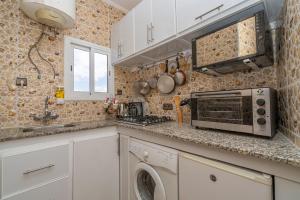 a kitchen with a microwave and a washer and dryer at Appartement Ensolleillé Au coeur De Tanger in Tangier