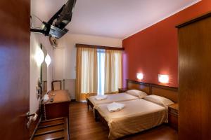 a bedroom with a bed with two towels on it at Nefeli Hotel in Kavála
