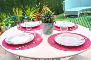 a table with red and white plates and a potted plant at CASA MIMAR moderna y acogedora in La Oliva