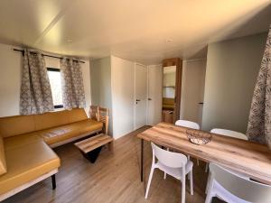 a living room with a couch and a table and chairs at Camping de la Lyre in Corsavy