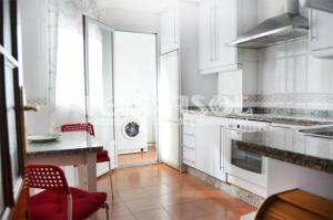 a kitchen with white cabinets and a red chair at Terrasol Azucarera Atico H in Torre del Mar