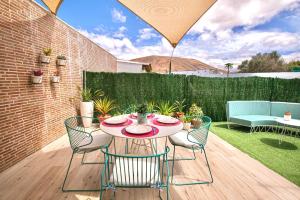 a patio with a table and chairs and a fence at CASA MIMAR moderna y acogedora in La Oliva