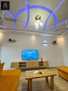 a living room with a table and a flat screen tv at SMART BÂTIPRO Appartement 2 chambres salon milieu in Cotonou +5 photos