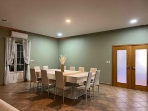 a dining room with a white table and chairs at Monte do Carapetal in Amareleja
