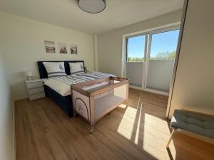 a bedroom with a bed and a large window at Urlaub an der Nordsee - Exklusive Penthouse-Ferienwohnung Deichliebe in Tossens in Butjadingen