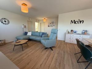 a living room with a blue couch and a table at Urlaub an der Nordsee - Exklusive Penthouse-Ferienwohnung Deichliebe in Tossens in Butjadingen