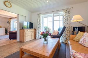 a living room with a vase of flowers on a coffee table at LH Westermüür, Hausteil 1 in Braderup