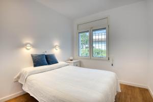 Un dormitorio blanco con una cama grande con almohadas azules. en P37 Villa, en Pals 25 fotos más