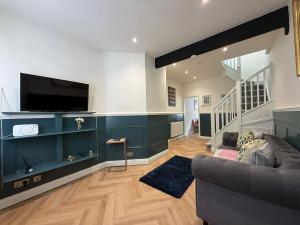 un soggiorno con divano e TV a schermo piatto di Charming cottage in WINDSOR - WALK TO CASTLE &SHOPS! a Windsor