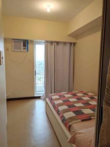a bedroom with a bed and a window with a balcony at The Intramuros Suite in Manila +26 photos