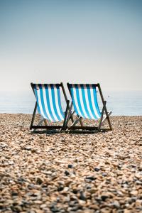 two beach chairs sitting on a rocky beach at Chic Brighton Studio in Brighton & Hove