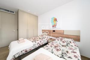 zwei Betten in einem Zimmer mit weißen Wänden in der Unterkunft Design Apartment Flamenco Garden at La Finca Golf - By Oyoostays in Algorfa