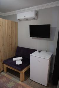 a living room with a couch and a tv at Sarp Bungalov in Kemalpasa