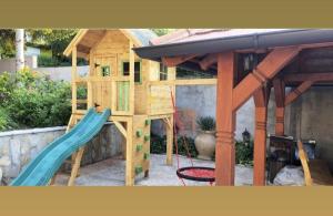 a wooden play house with a slide and a surfboard at Brvnara Petra in Berkovac