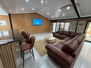 a living room with a couch and a bar at Swaelkrans Private Hunting Reserve - Delta Lodge in Bothaville