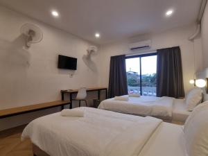 a hotel room with two beds and a window at Lunar Hostel in Vientiane