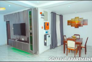 ein Wohnzimmer mit Tisch und Fernseher in der Unterkunft Soalive Apartments in Lagos