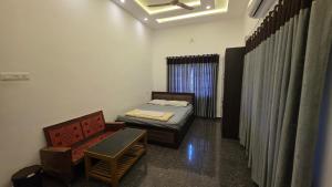 a room with a bed and a couch and a window at Serahs Homestay in Agali