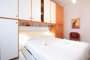 a bedroom with a white bed and white cabinets at PrimoPiano - Padova 217A in Milan