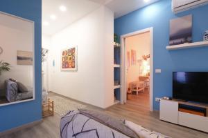 a living room with blue walls and a tv at PrimoPiano - Padova 217A in Milan