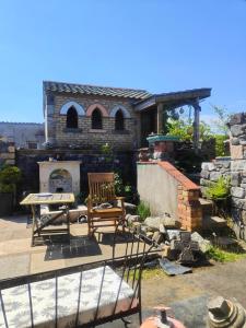 a patio with chairs and a fireplace in front of a house at Bohemian Bell Tent in Kinvara County Galway in Kinvara