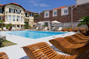 a swimming pool with lounge chairs next to a building at La Garoupe-Gardiole in Antibes