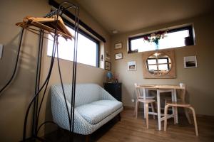 a living room with a chair and a table at Le petit Préau 10 min plages in Coudeville