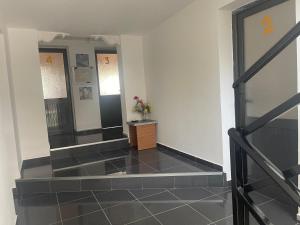 a hallway with black tile floors and two mirrors at Guesthouse Airbase in Ura Vajgurore +47 photos