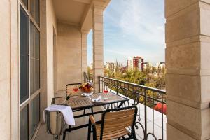 einen Balkon mit einem Tisch und Stühlen in der Unterkunft Ambassador Hotel in Bischkek