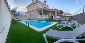 a house with a swimming pool and some chairs at Apartament Casa Bonfill in L'Ampolla