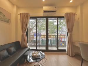 a living room with a couch and a large window at Happy Home - Big Balcony - Best Location in Hanoi