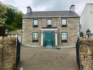 a stone house with a blue door in a driveway at Crossroads Portsalon in Portsalon
