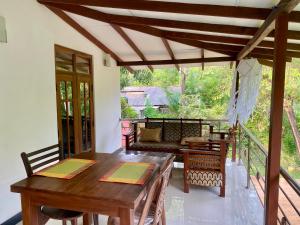 a porch with a wooden table and a couch at Habarana New Star Homestay in Habarana