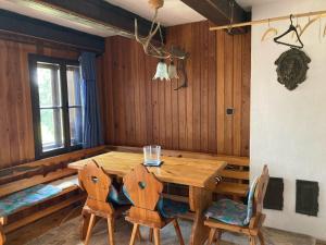 a dining room with a wooden table and chairs at Gallys Mounting Cottage Pod Boubinem in Lenora