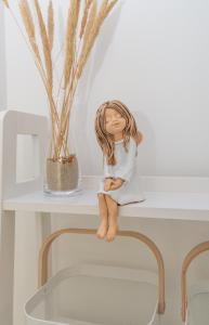 a little girl sitting on top of a shelf at Atnaujinti buvę poilsio namai "Nidos Rūta" in Nida