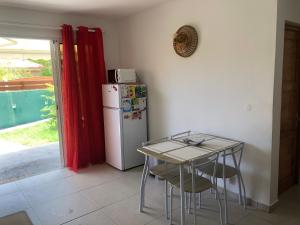 a kitchen with a small table and a refrigerator at Les Âmes-Claires 1 in Terre-de-Haut