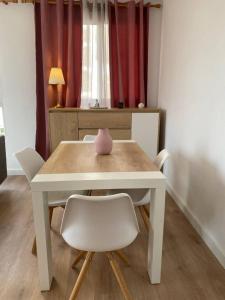 a white table with white chairs and a pink vase on it at Apartamento Plaza de las Flores in Murcia