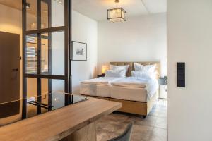 a bedroom with a bed and a glass table at Elbe6 - 5 Sterne Apartments in Wittenberge