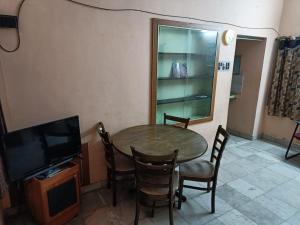a dining room with a table and chairs and a tv at Adb's Srirangam Homes at Gandhi Road in Tiruchirappalli