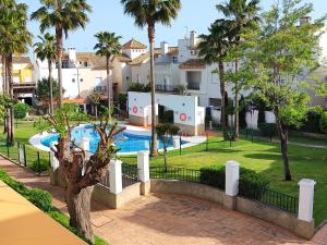 a resort with a swimming pool and palm trees at Casa Playa Las Redes in El Puerto de Santa María