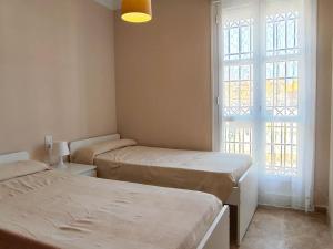 a room with two beds and a window at Casa Playa Las Redes in El Puerto de Santa María +21 photos