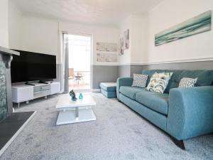 a living room with a blue couch and a tv at 46 Dalby Road in Leicester