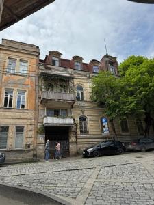 dos personas de pie en frente de un edificio viejo en Cozy Apartment in Old Town Tbilisi, en Tiflis