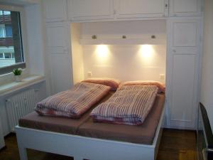 ein Bett mit zwei Kissen darauf in einem Zimmer in der Unterkunft Strandappartement in Westerland