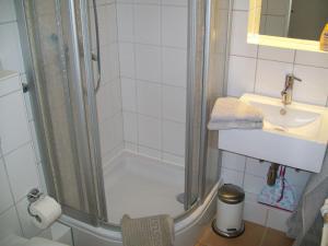 ein Badezimmer mit Dusche und Waschbecken in der Unterkunft Strandappartement in Westerland