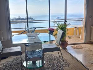 a table and chairs in a room with a view of the ocean at MONACO - FANTASTIC Apartment and Sea View -1 bedroom 80m2 in Roquebrune-Cap-Martin