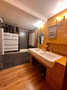 a bathroom with a sink and a mirror and a tub at La Parenthèse à La Llagonne in La Llagonne +19 photos
