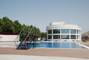 a large building with a pool and a staircase next to it at Agsaray Deluxe Hotel & SPA in Mingachevir